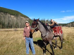 Bighorn ram on horseback after hunting in Alberta